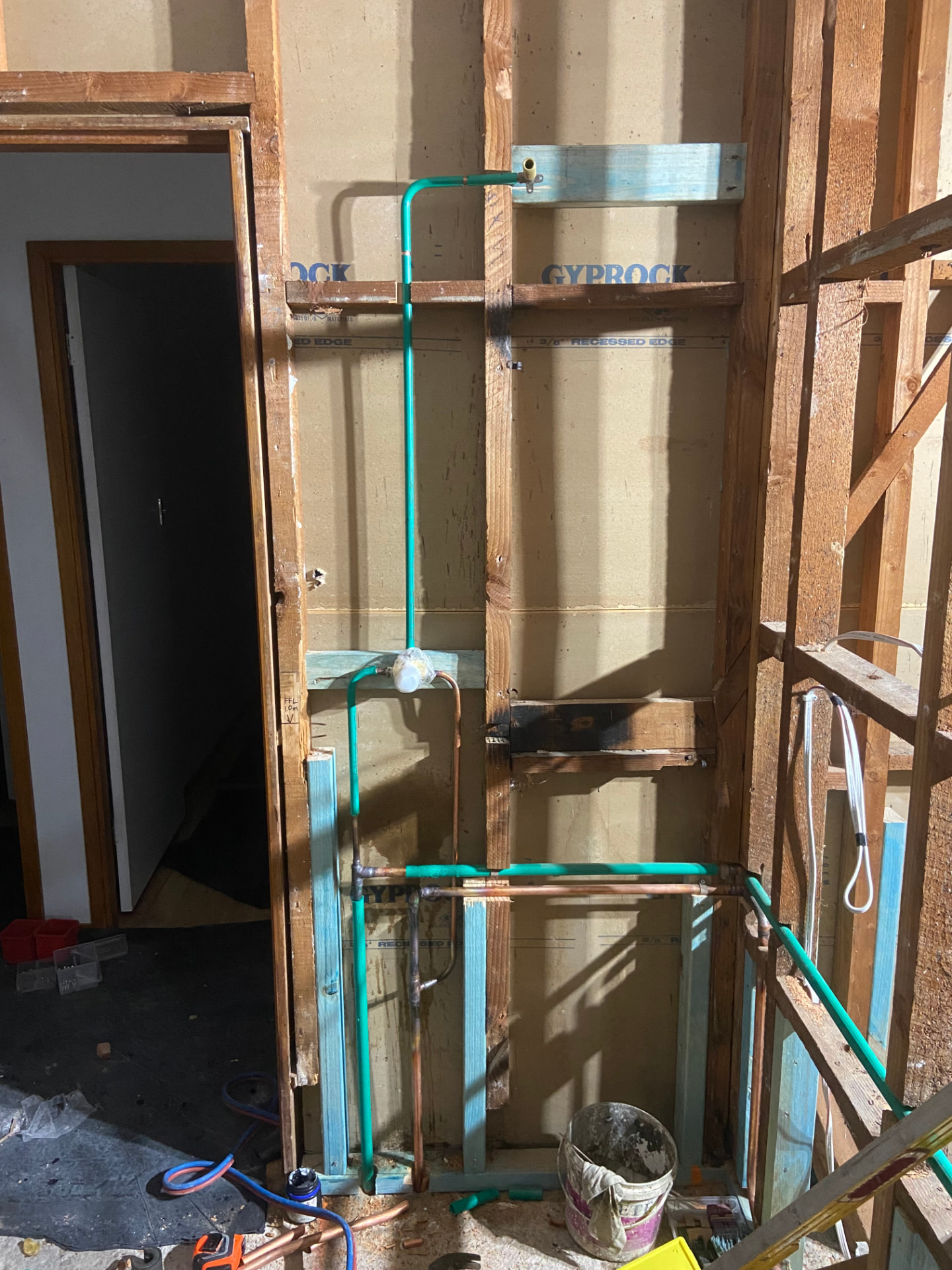 Bathroom renovation rough-in with copper pipework and shower mixer set into wall framing