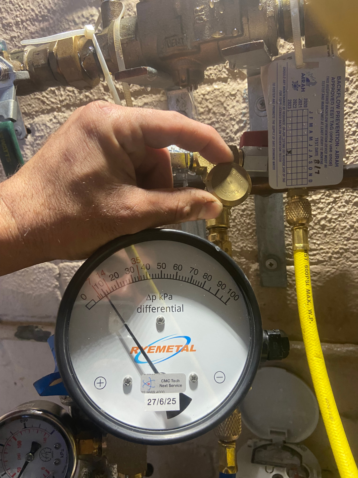 Calibrated differential pressure gauge connected to a backflow prevention device during annual testing