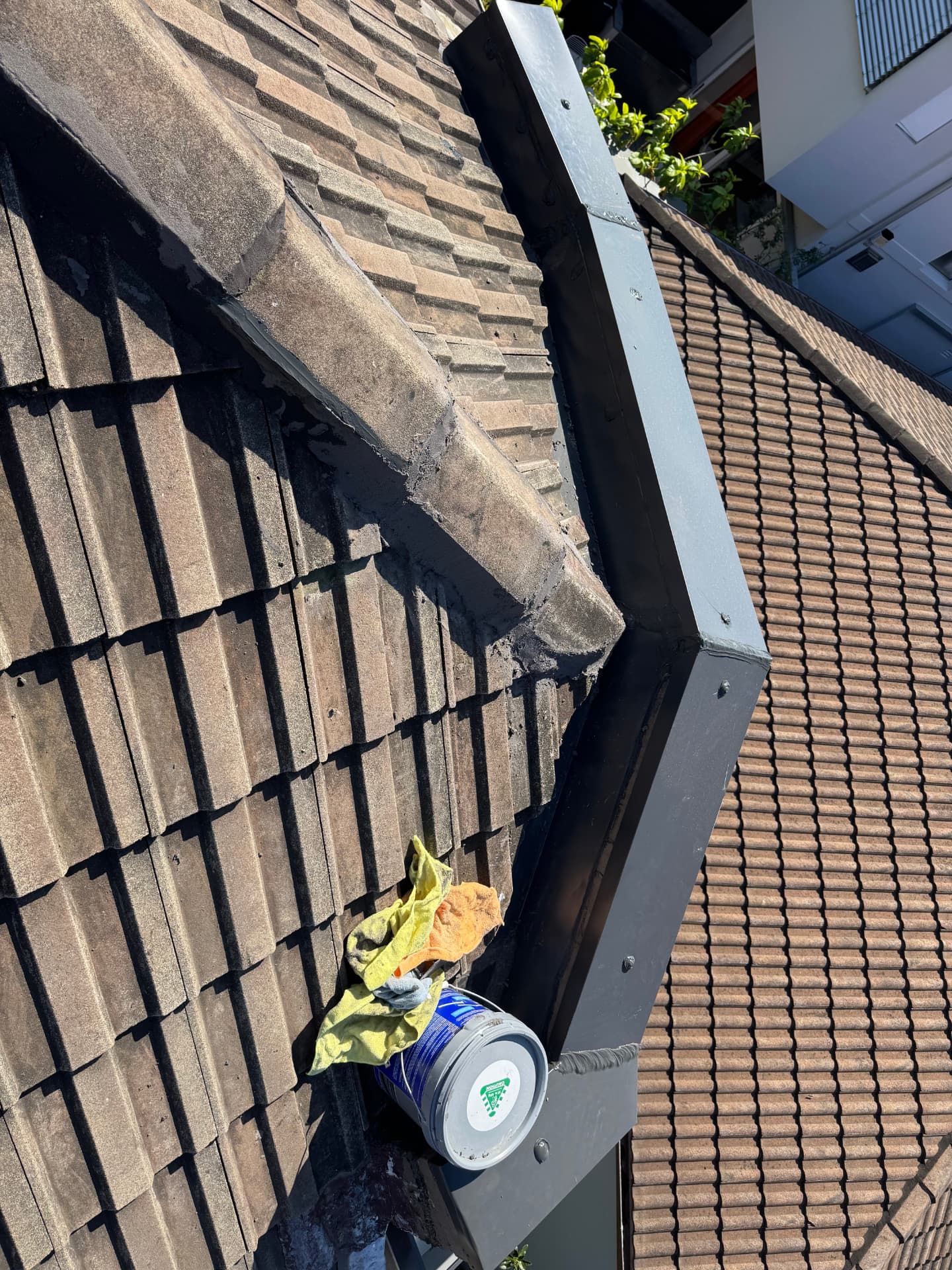 Tiled roof valley and parapet capping repaired and re-sealed with new flashing during a Sydney roof plumbing repair