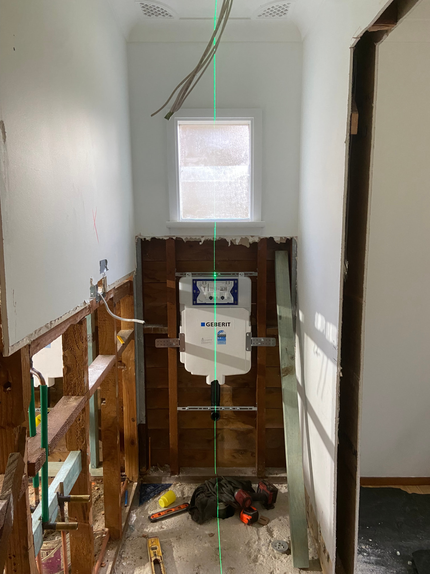Toilet set-out with laser line during bathroom renovation plumbing