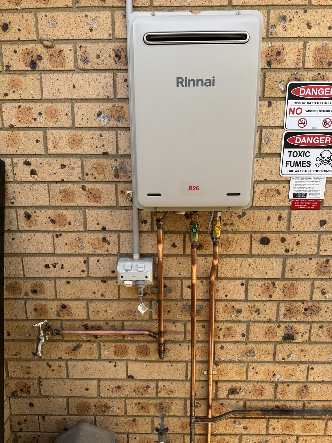 Rinnai B26 natural gas continuous flow hot water unit installed on a brick wall with new copper hot, cold and gas connections
